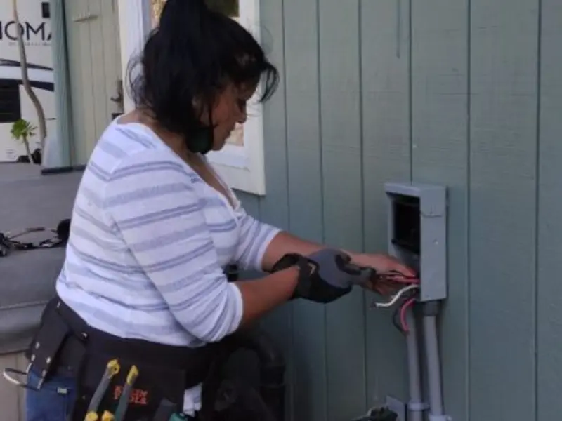 Licensed electrician wiring an exterior subpanel in Bethel